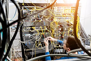 Network engineer working in server room. Connecting network cables to switches