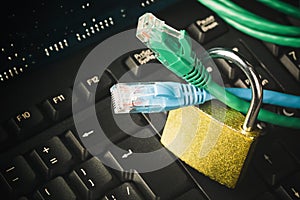 Network ethernet cables in padlock on computer keyboard. Internet data privacy information security concept. Toned image