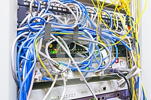 Network interfaces with a lot of tangled wires. Rack with Internet equipment