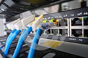 Network switch and ethernet cable in rack cabinet. Network connection technology and has a status LED to show working status.