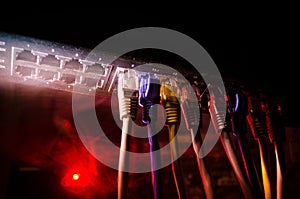 Network switch and ethernet cables, symbol of global communications. Colored network cables on dark background with lights and smo