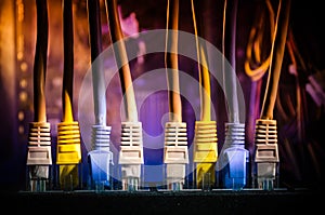 Network switch and ethernet cables, symbol of global communications. Colored network cables on dark background with lights and smo