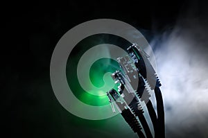 Network switch and ethernet cables, symbol of global communications. Colored network cables on dark background with lights and smo