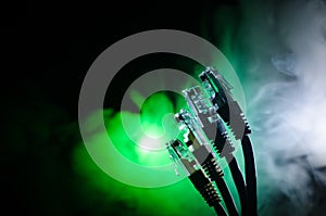 Network switch and ethernet cables, symbol of global communications. Colored network cables on dark background with lights and smo