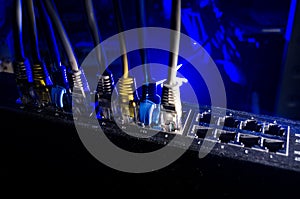 Network switch and ethernet cables, symbol of global communications. Colored network cables on dark background with lights and smo