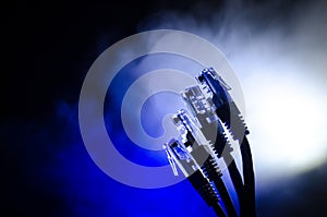 Network switch and ethernet cables, symbol of global communications. Colored network cables on dark background with lights and smo