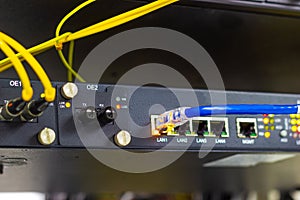 Network switch in rack, blue network cables connect SFP module port