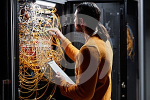 Network technician working with servers and connecting cables