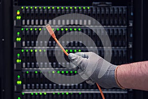 Network wires in the hands of a man at the server for data storage, clo