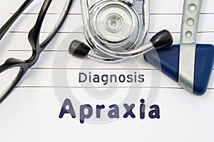 Neurological diagnosis of Apraxia. Neurological hammer, stethoscope and doctor`s glasses lie on doctor workplace on sheet of noteb