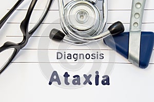 Neurological diagnosis of Ataxia. Neurological hammer, stethoscope and doctor`s glasses lie on doctor workplace on sheet of notebo photo