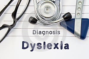 Neurological diagnosis of Dyslexia. Neurological hammer, stethoscope and doctors glasses lie on doctor workplace on sheet of noteb