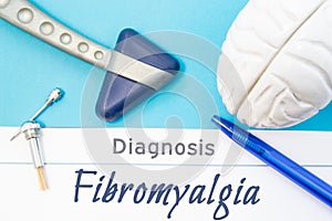 Neurological diagnosis of Fibromyalgia. Neurological hammer, human brain figure, tools for sensitivity testing are on table next t photo
