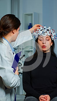 Neurological doctor cheking eeg headset explaining treatment