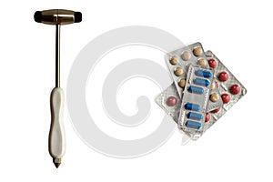 neurological hammer and stack of colorful pills in blisters isolared on white. background with copy space