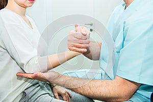 Neurological physical examination of the hands reflexes. Doctor neurologist checks the status of the patient`s reflexes in office