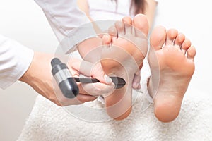 A neurologist doctor checks the plantar reflex in a patient s girl with a neurological hammer. Diagnosis of multiple sclerosis photo