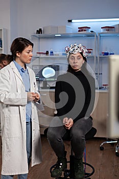 Neurologist doctor showing tomography expertise to woman patient with eeg scanner