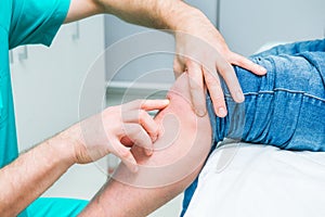 The neurologist doctor testing knee of male patient by finger pulpation. Neurological physical examination. Selective focus, close