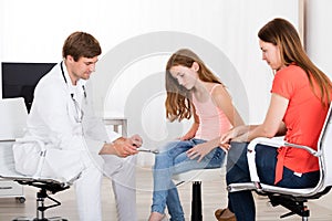 Neurologist Examining Knee Reflex On Girl photo