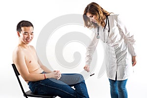 The neurologist testing knee reflex on a female patient using a