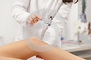 Neurologist testing knee reflex using reflex hammer. Neurological physical examination. Orthopedist work. Medical