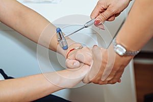 The neurologist testing reflex on a female patient using a hammer