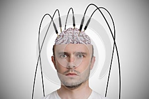Neuroscience and brain research concept. Young man has cables and electrodes in his brain photo