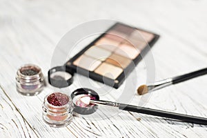 Neutral eye shadows, pigments, glitter, brushes and eyeliner