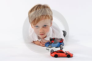 Neutral and innocent look of a kindergarten child after playing with a car toys