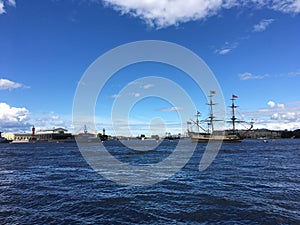 The Neva River with the sailing ship Poltava and warships lined up for the naval parade in St. Petersburg against the background
