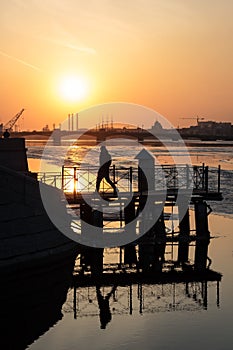 Neva river winter sunset, human siluette and reflection