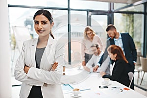 We never downscale on our ambitions in this office. Portrait of a young businesswoman standing in an office with her