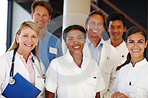 We never fail to deliver. A shot of a group of medical professionals smiling at the camera.