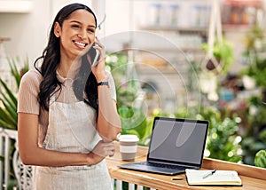 Never gave up, never gave in. a young florist using her smartphone to make a call while using a laptop.