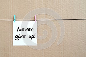 Never give up! Note is written on a white sticker that hangs wit