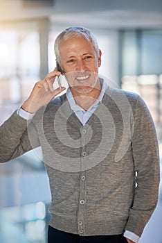 He never leaves his clients hanging. Shot of a mature businessman making a phonecall while walking in his office.