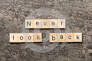 never look back word written on wood block. never look back text on cement table for your desing, concept
