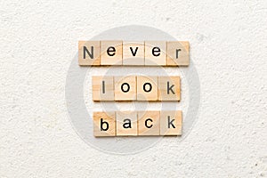 never look back word written on wood block. never look back text on cement table for your desing, concept