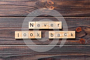 Never look back word written on wood block. never look back text on wooden table for your desing, concept