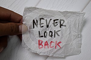 Never Look Back write on crunched paper isolated on wooden table photo