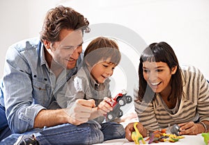 Never mind the mess, were making memories. happy parents playing with their son and his toys.