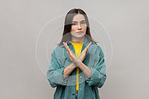 Dissatisfied woman crossing hands, showing x sign, ban or prohibition gesture, rejecting offer.