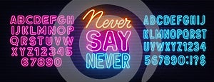 Never Say Never neon quote on a brick wall.