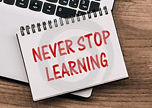 Never stop learning written on a memo stick. Lifelong learning concept photo