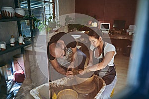 Never stop the wheel of learning turning. a young man and woman working with clay in a pottery studio.