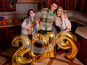 New 2019 Year is coming. Group of cheerful young people carrying gold colored numbers and have fun at the party