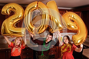 New 2019 Year is coming. Group of cheerful young people carrying gold colored numbers and have fun at the party