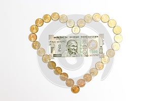 New 500 rupees banknotes and coins on white background. Heartshape concept