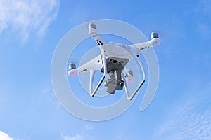 The New Aircraft DJI Phantom 4 pro quadcopter drone with 4K video camera and wireless remote controller flying in the sky. Aerial